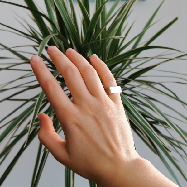Silver square ring, photographed on a hand