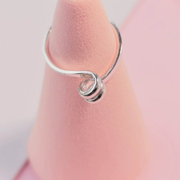 Silver ring with swirl on top, photographed from the top