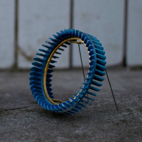 Brooch in blue colour and gold tension setting
