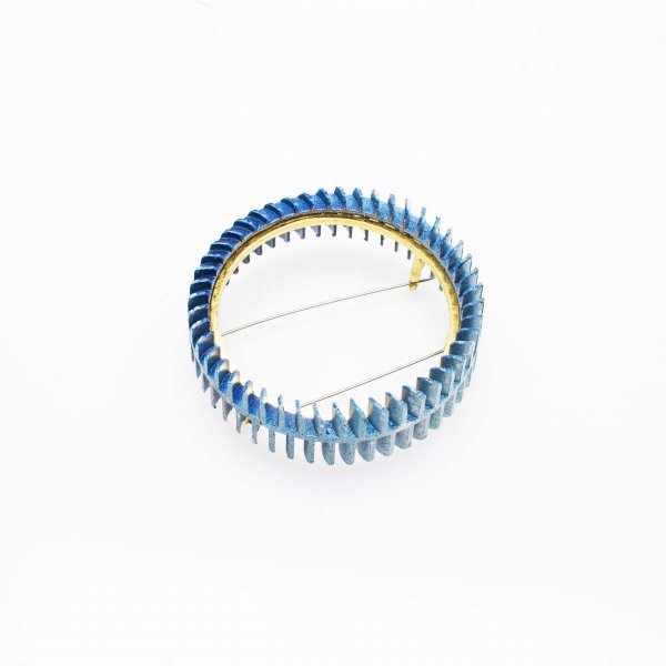 Brooch in blue colour and gold tension setting